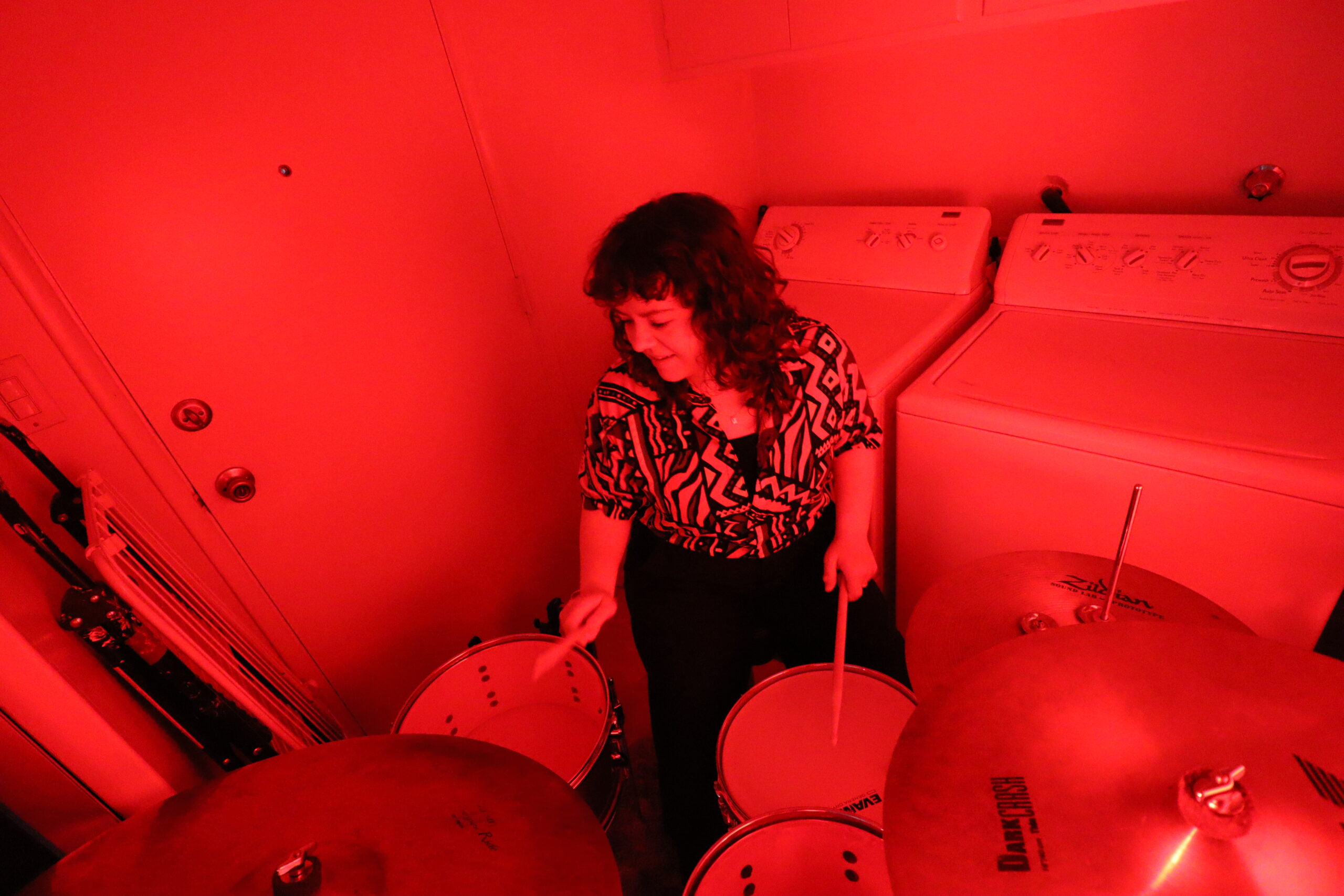 Lindsay Artkop drumming in red lights